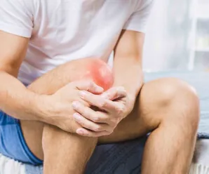 Man holding his knee while sitting, showing joint discomfort